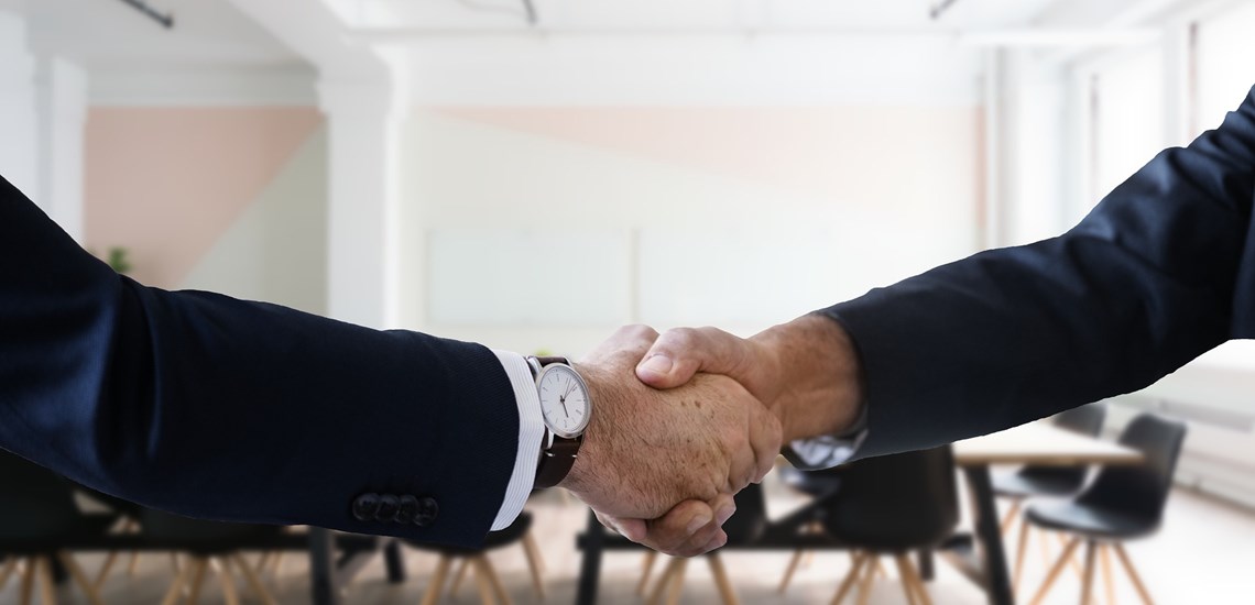business people shaking hands in boardroom