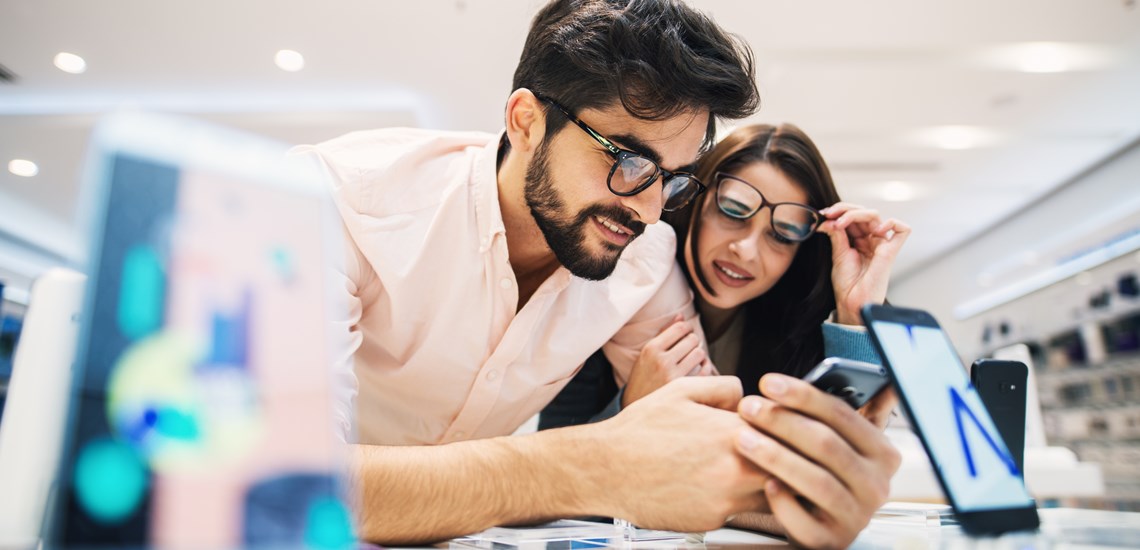 young couple reviewing finances on mobile phone