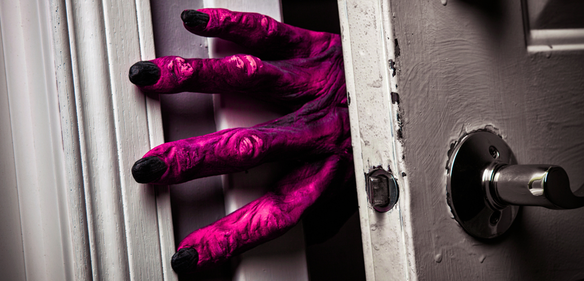Big, purple monster hand reaching around a doorframe.