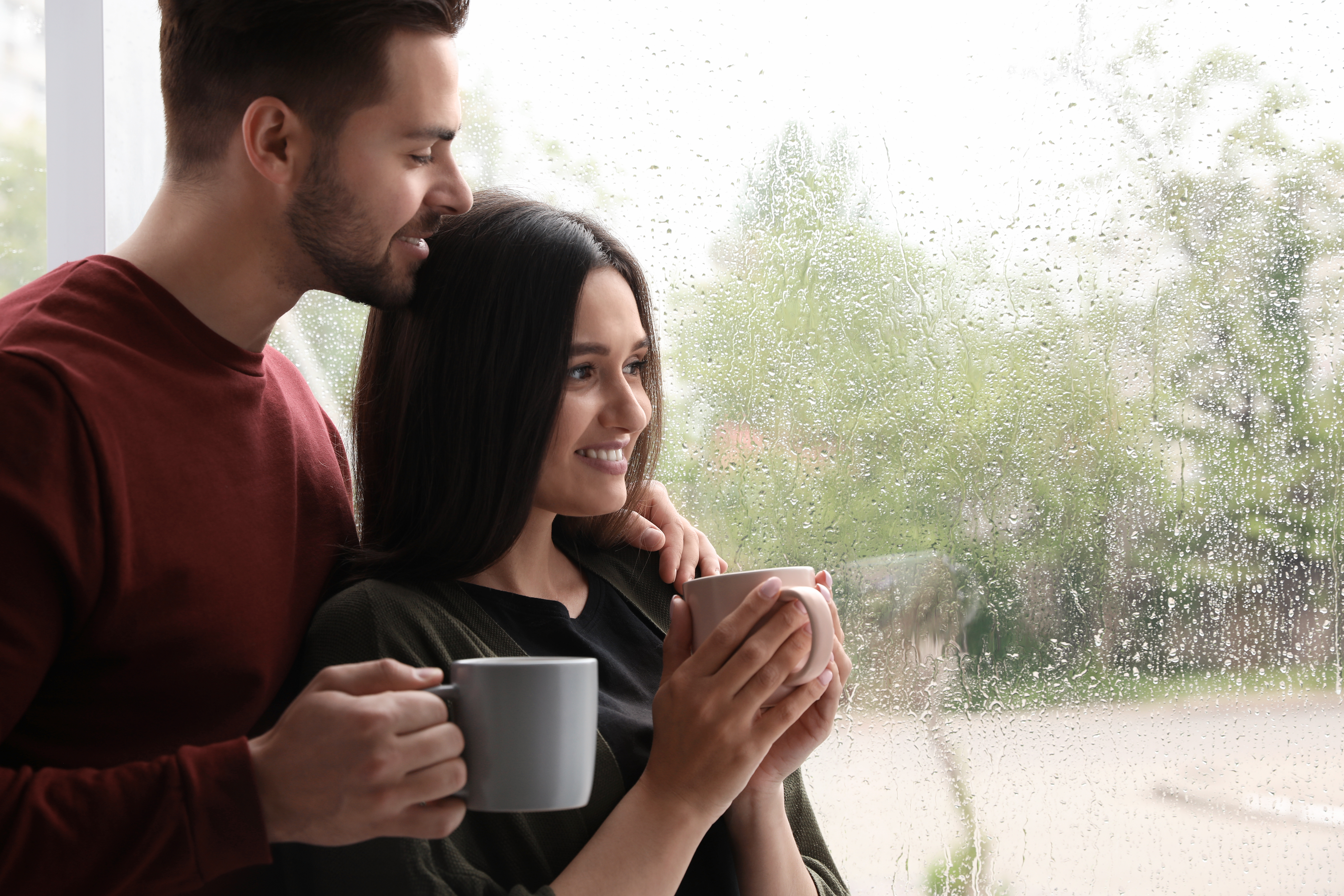man and woman standing by window
